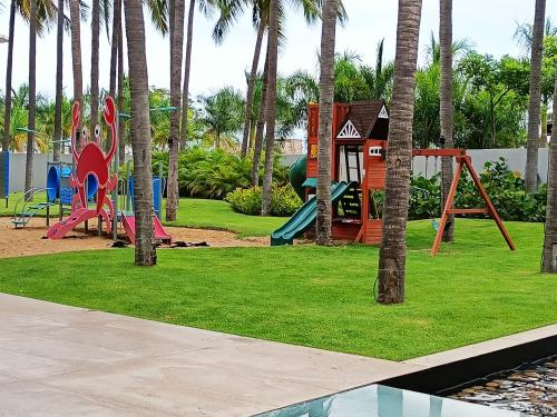 un parque infantil con palmeras y una estructura de juegos en Peninsula Nuevo Vallarta, en Nuevo Vallarta 