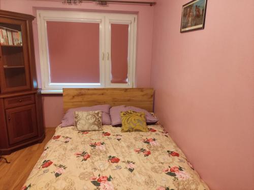 a bedroom with a bed with two pillows on it at Przy Parku in Jarosław