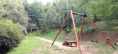an empty park with two swings and a bench at Karancs Apartman Salgótarján in Salgótarján