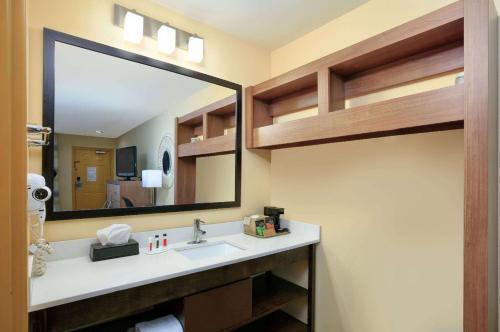 a bathroom with a sink and a large mirror at Days Inn by Wyndham Batesville in Batesville
