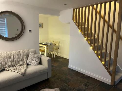 a living room with a couch and a stair case at Mount Cottage in Conwy