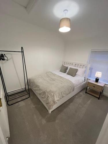 a white bedroom with a bed and a mirror at Mount Cottage in Conwy