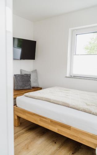 a white bedroom with a bed and a window at Wohnen auf Zeit in Weingarten in Weingarten