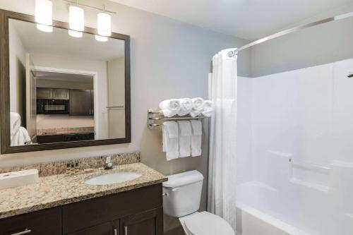 a bathroom with a sink and a toilet and a mirror at Hawthorn Suites by Wyndham Dickinson in Dickinson