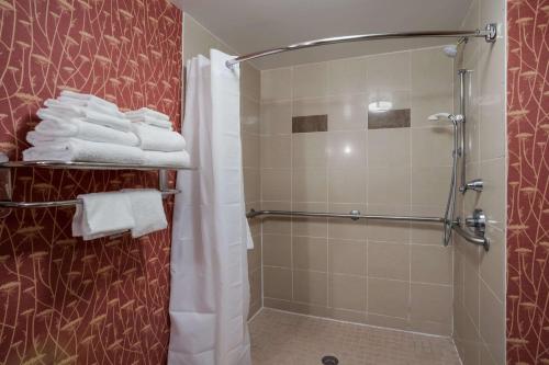 uma casa de banho com um chuveiro e toalhas brancas em Comfort Suites Suffolk - Chesapeake em Suffolk