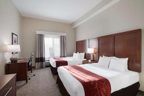 a hotel room with two beds and a desk at Comfort Suites Suffolk - Chesapeake in Suffolk