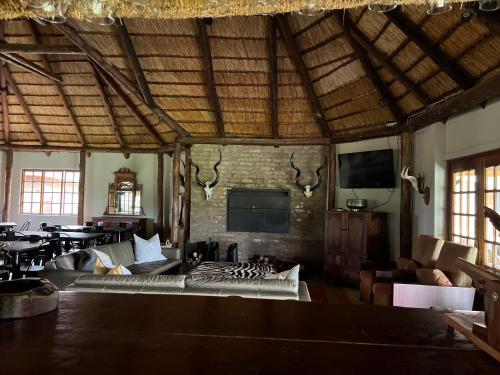 a large living room with a fireplace and a tv at Vilagama Game Lodge in Naboomspruit