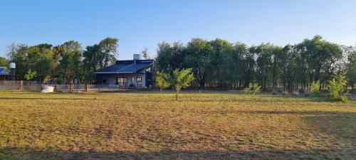 a house in the middle of a field at Casa Brunia Lago Los Molinos in Villa General Belgrano