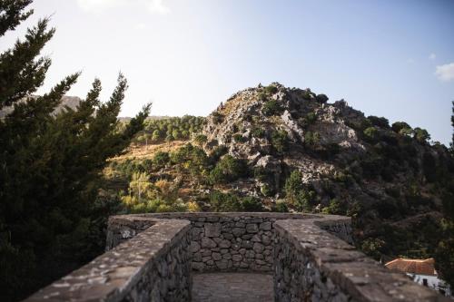 una pared de piedra con una montaña en el fondo en Camping TajoRodillo, en Grazalema