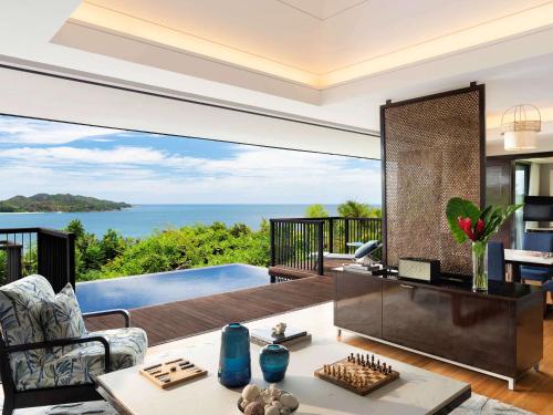 a living room filled with furniture and a view of the ocean at Raffles Seychelles in Baie Sainte Anne