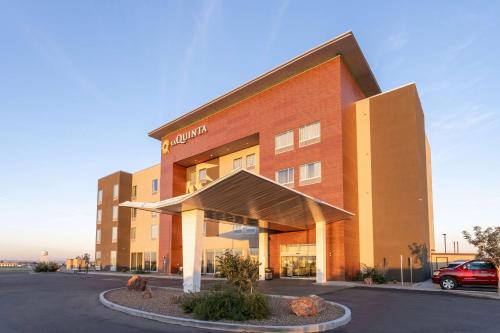 a hotel building with a car parked in a parking lot at La Quinta Inn & Suites by Wyndham Holbrook Petrified Forest in Holbrook