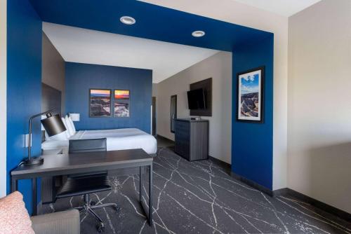 a hotel room with a bed and a desk in it at La Quinta Inn & Suites by Wyndham Holbrook Petrified Forest in Holbrook