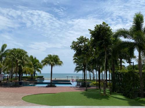 un complejo con piscina, palmeras y océano en Timurbay Residence with Seaview 6pax 2Bedrooms Level 9 Kuantan, en Kampung Sungai Karang