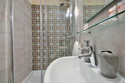 un bagno con un lavandino bianco e una doccia di Vallettastay Old Lodge Apartment 1 a La Valletta