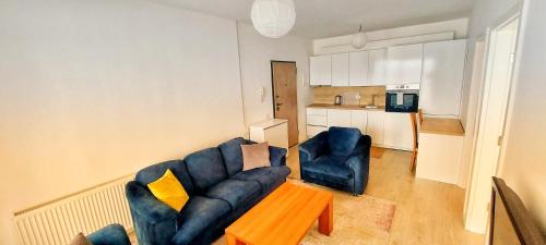 a living room with a blue couch and a table at Sunflower Apartments in Pristina