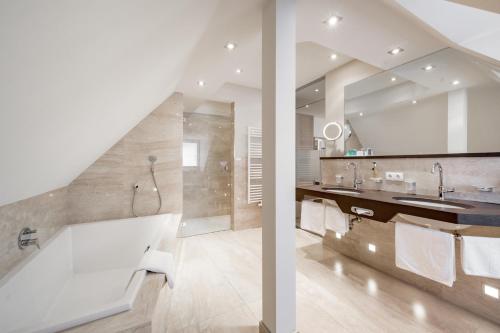 a bathroom with a large tub and a sink at Hotel Garni Christine in Ischgl