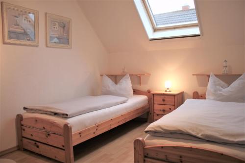 two twin beds in a room with a window at Robby1 in Kaltenhof