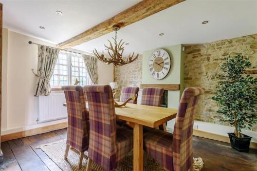 a dining room with a wooden table and chairs at 14th Century Medieval Longhouse 