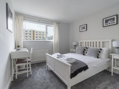 a white bedroom with a bed and a window at Howick House - Large 3 bedroom house, Gosforth in Kenton