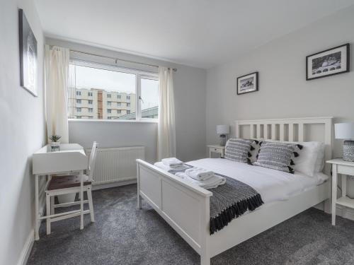 a white bedroom with a bed and a window at Howick House - Large 3 bedroom house, Gosforth in Kenton