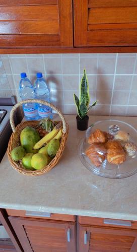 a counter with a basket of fruit and a plate of food at Armelle Sweet Home in Douala