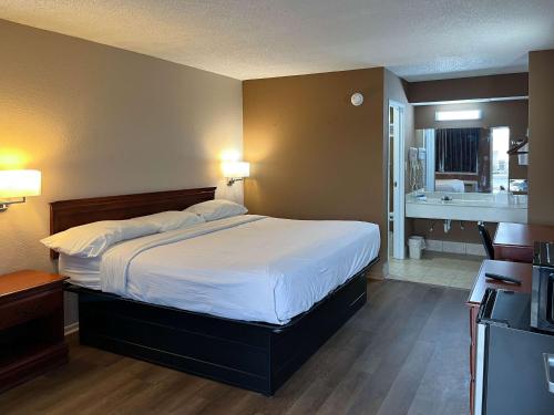 1 Schlafzimmer mit einem großen Bett und einem Badezimmer in der Unterkunft Motel 6 Millington TN in Millington