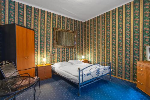 a bedroom with a bed and a chair in it at Residence Seven Angels in Prague