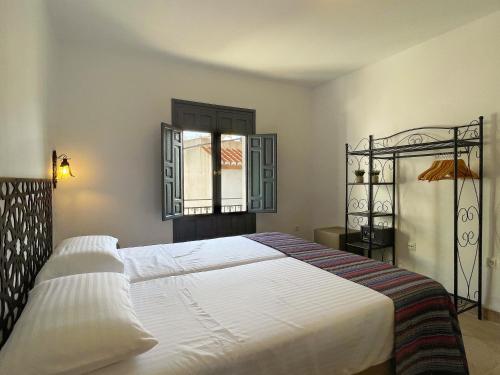 Un dormitorio con una cama grande y una ventana en Las Tres Hermanas en Salobreña
