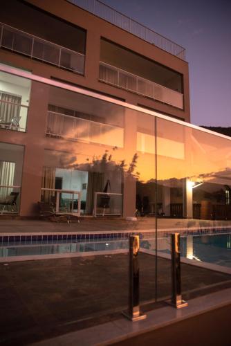 a building with a swimming pool in front of it at Paraíso da Enseada de Brito in Palhoça