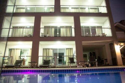a hotel with a swimming pool in front of a building at Paraíso da Enseada de Brito in Palhoça
