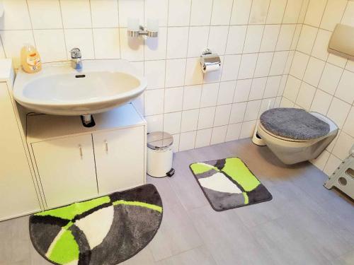 y baño con lavamanos, aseo y alfombra. en Ferienwohnung Wenzl, en Zandt