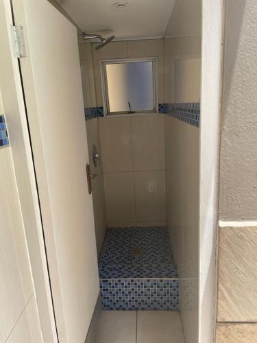 a small bathroom with a shower with blue tiles at Oceanic View in Durban