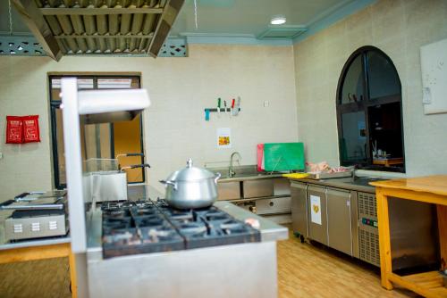 a kitchen with a stove with a pot on it at The Garden Place Hotel in Ruhengeri