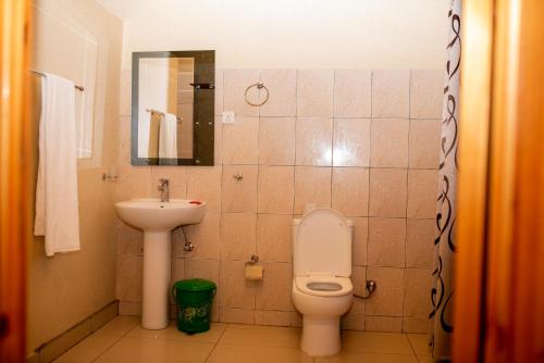 uma casa de banho com um WC e um lavatório em The Garden Place Hotel em Ruhengeri