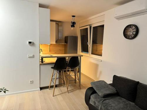 a living room with a couch and a kitchen at Atraktivan studio apartman in Zagreb