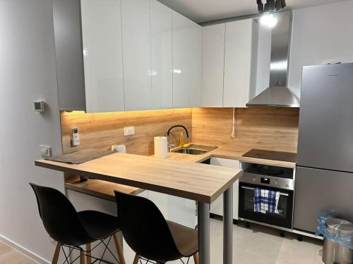 eine Küche mit weißen Schränken und einer hölzernen Arbeitsplatte in der Unterkunft Atraktivan studio apartman in Zagreb