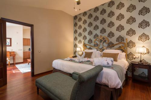 a bedroom with two beds and a chair in it at Laguna Nivaria Hotel & Spa in La Laguna