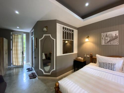 - une chambre avec un grand lit et un miroir dans l'établissement Perennial Resort, à Nai Yang Beach