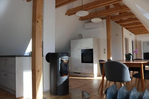 a kitchen and dining room with a stove and a table at Drei-Seiten-Hof Étable mit Schwimmteich und Klimanlage in Fuchshain