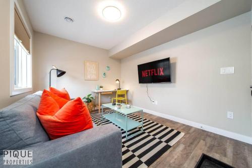 a living room with a couch and a tv at NEW, Euro-Style Suite, Whyte Avenue, AC, Netflix, Sleeps 6! in Edmonton
