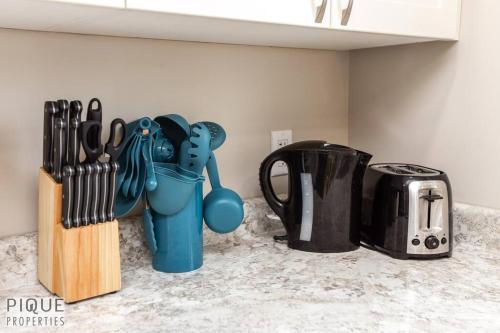a kitchen counter top with a blue utensil holder and knives at NEW, Euro-Style Suite, Whyte Avenue, AC, Netflix, Sleeps 6! in Edmonton