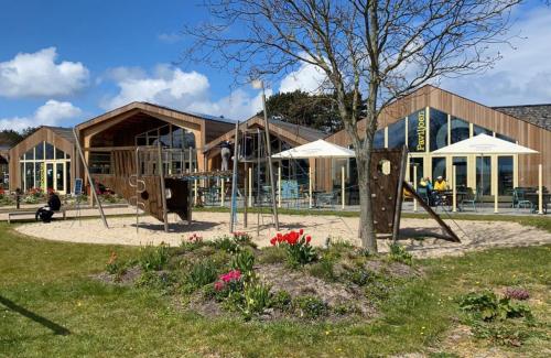 une aire de jeux en face d'un bâtiment dans l'établissement Panoramatent, in de natuur aan zee, à Callantsoog