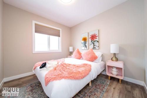 a bedroom with a large white bed with pink pillows at NEW, Euro-Style Suite, Whyte Avenue, Netflix, Sleeps 6! in Edmonton