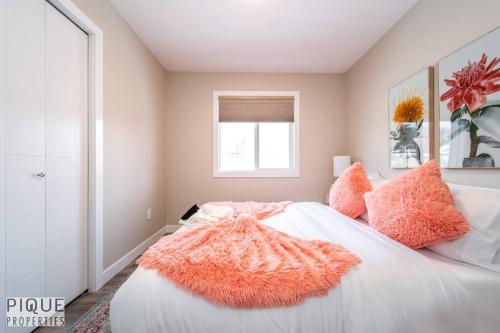 a bedroom with a bed with an orange blanket on it at NEW, Euro-Style Suite, Whyte Avenue, AC, Netflix, Sleeps 6! in Edmonton
