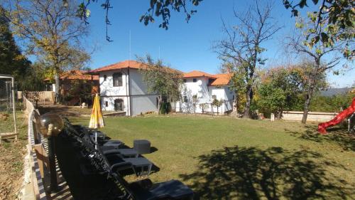 a house with a row of chairs in a yard at Арт комплекс Горски дом - Трявна in Tryavna
