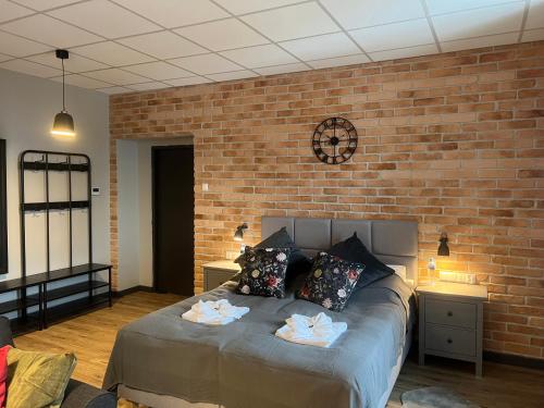 a bedroom with a large bed with a brick wall at Apartamenty Skierniewice Mireckiego in Skierniewice