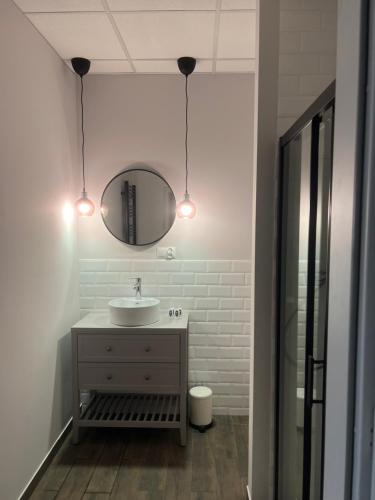 W łazience znajduje się umywalka i lustro. w obiekcie Apartamenty Skierniewice Mireckiego w mieście Skierniewice