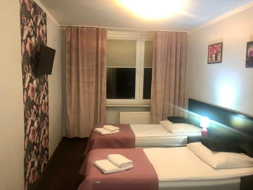 a hotel room with two beds and a window at Sosnowe Zacisze in Białystok