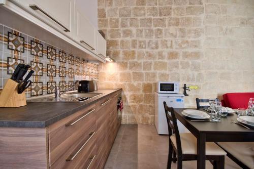 a kitchen with a table and a counter top at Vallettastay Old Lodge Apartment 3 in Valletta