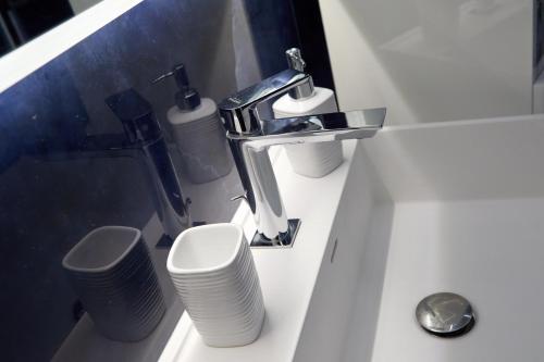 a bathroom with a sink with two toilets and a faucet at Palazzina Margò in Mola di Bari